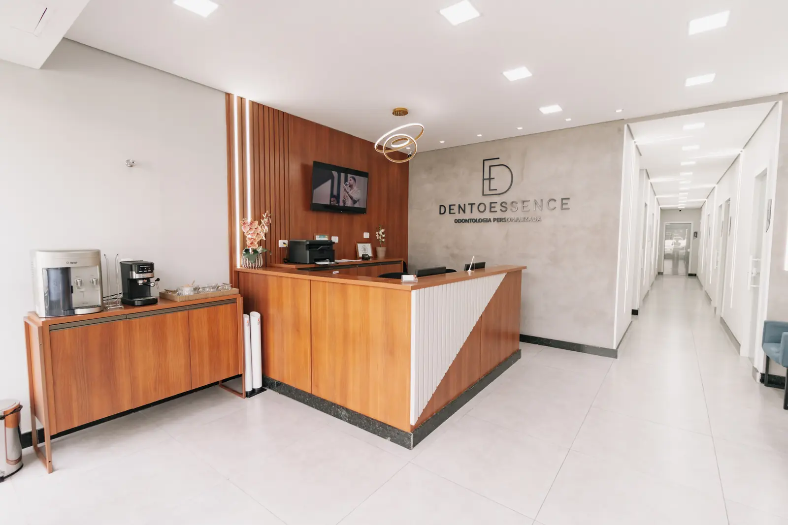 Recepção da DentoEssence Santos com corredor de acesso aos consultórios